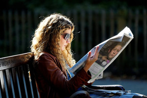 Девушка читает газету